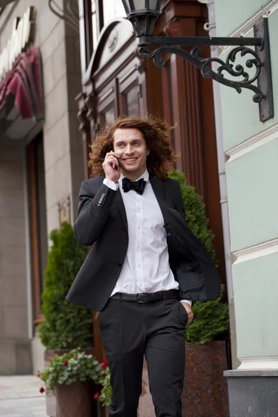 Jovem empresário alegre chamando por telefone — Fotografia de Stock