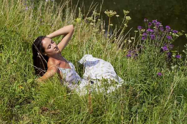 Jeune femme sur prairie verte — Photo