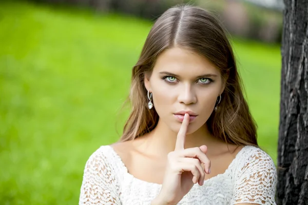 Woman has put forefinger to lips as sign of silence — Stock Photo, Image