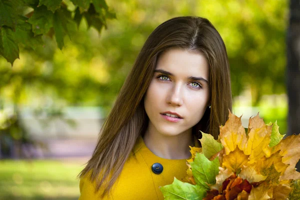 Joyeux jeune femme en manteau jaune dans le parc d'automne — Photo