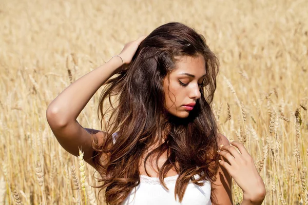 Jeune femme dans un champ de blé doré — Photo