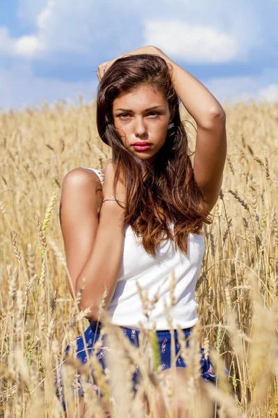 Mujer joven en un campo de trigo dorado —  Fotos de Stock