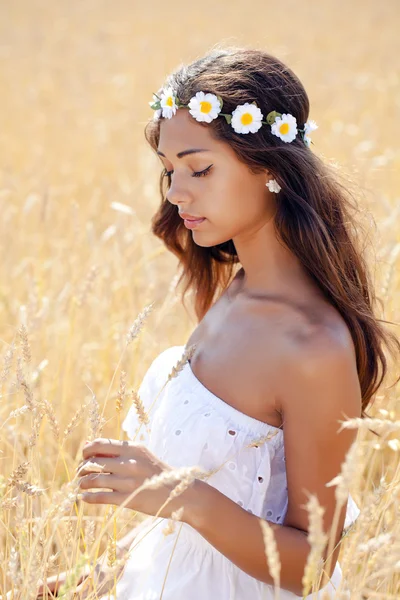 Jovem mulher em um campo dourado de trigo — Fotografia de Stock