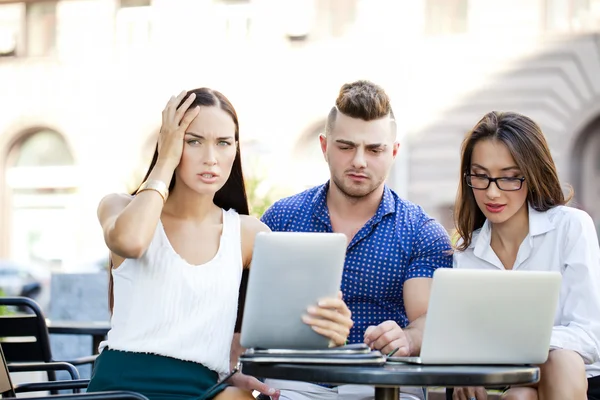 Equipe de negócios inter-racial trabalhando no laptop em um escritório ao ar livre — Fotografia de Stock