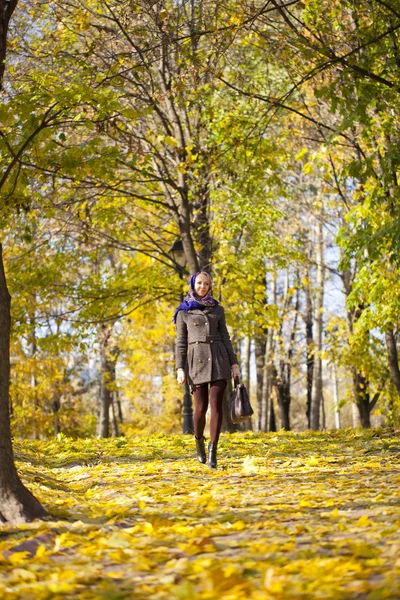Ung kvinna promenader i höstparken — Stockfoto