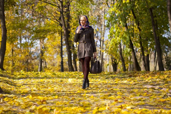 Young woman walking in autumn park — Stock Photo, Image