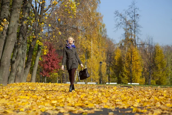 Mladá žena kráčí v podzimním parku — Stock fotografie