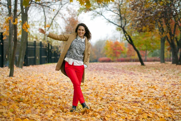 Młoda kobieta moda płaszcz spaceru w parku jesień — Zdjęcie stockowe