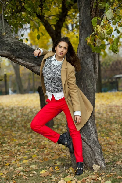 Jonge vrouw met mode vacht wandelen in herfst park — Stockfoto