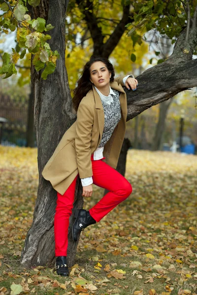 Junge Frau in Modemantel spaziert durch Herbstpark — Stockfoto