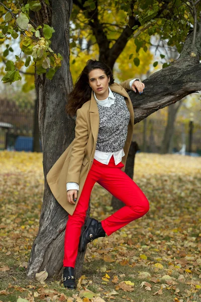 Jonge vrouw met mode vacht wandelen in herfst park — Stockfoto