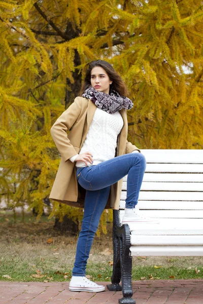 Mujer joven en abrigo de moda caminando en el parque de otoño — Foto de Stock