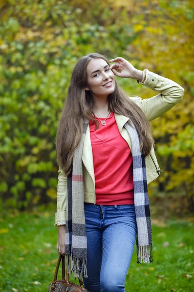 Jeune femme en manteau de mode marche dans le parc d'automne — Photo