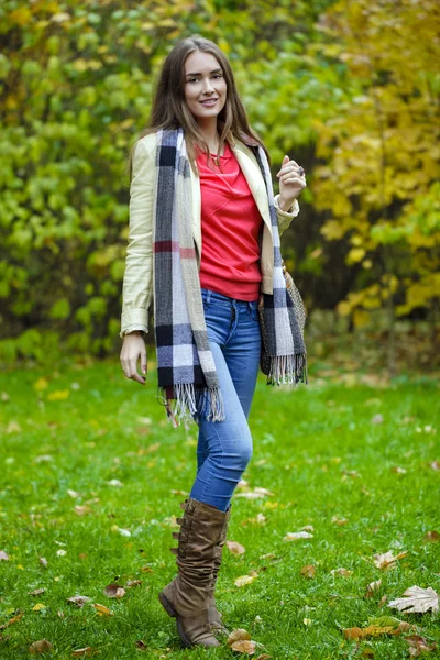 Jovem mulher de casaco de moda andando no parque de outono — Fotografia de Stock