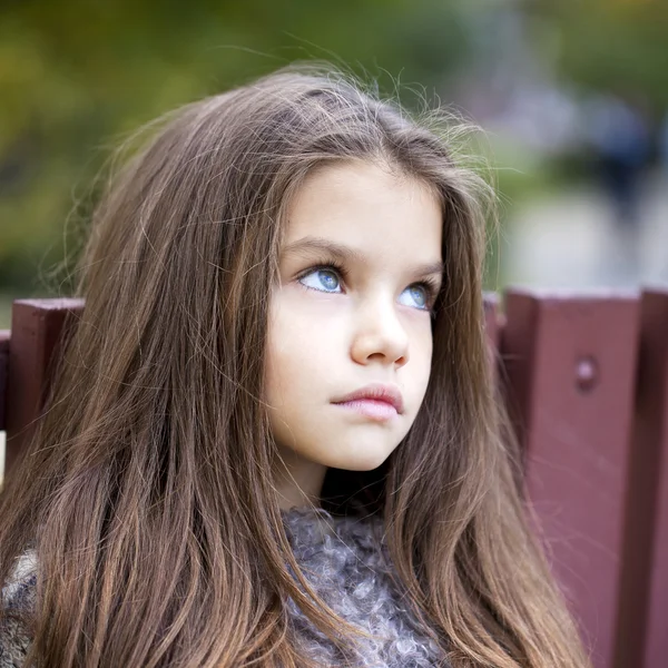 Peřeje v podzimním parku holčička — Stock fotografie