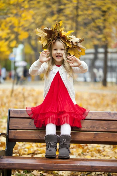 Vacker liten flicka satt på en bänk — Stockfoto