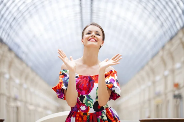 Belle femme en robe de fleurs rouges dans la boutique — Photo