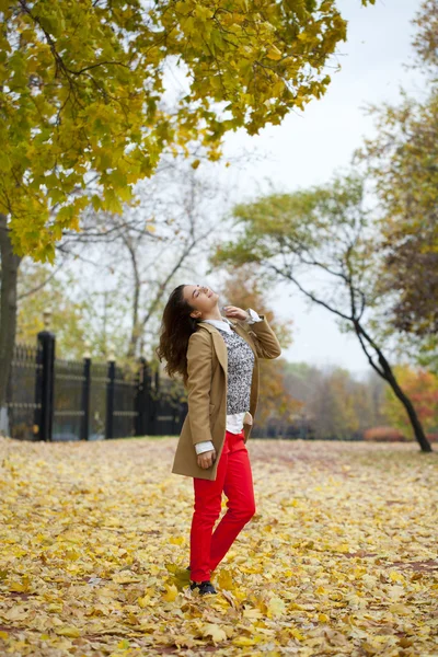 Junge Frau in Modemantel spaziert durch Herbstpark — Stockfoto