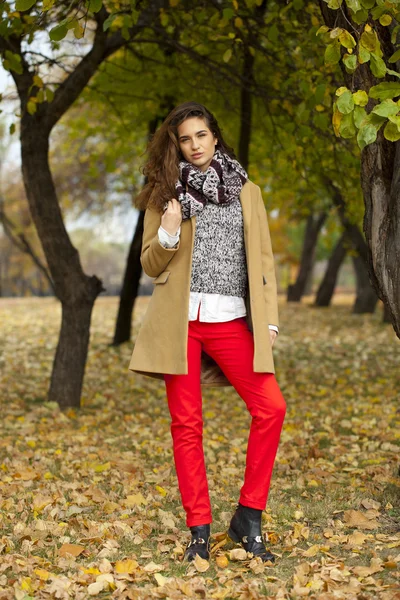 Jonge vrouw met mode vacht wandelen in herfst park — Stockfoto