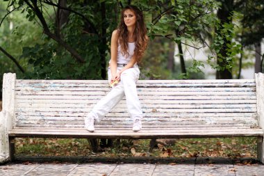 Sonbahar parkta bir bankta oturan güzel kadın