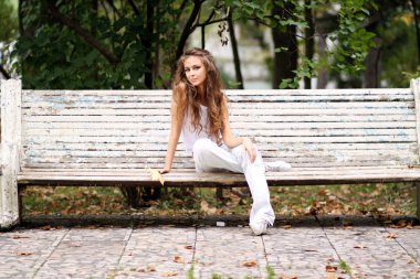 Sonbahar parkta bir bankta oturan güzel kadın