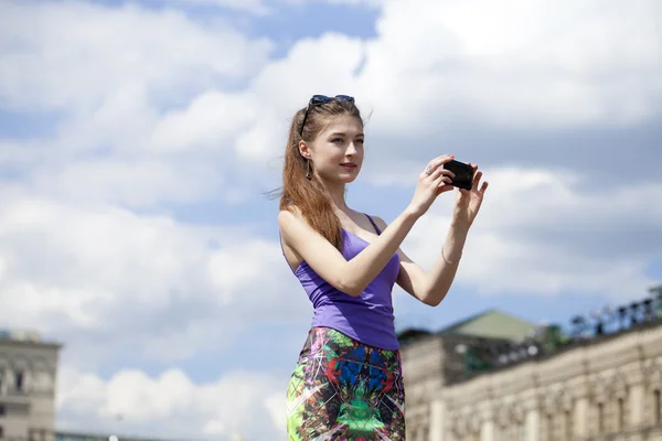 Felice bella ragazza fotografata su un telefono cellulare — Foto Stock