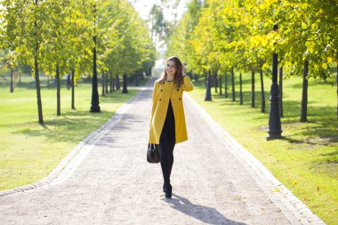 mutlu bir kadın sarı montlu sonbahar street yürüyüş