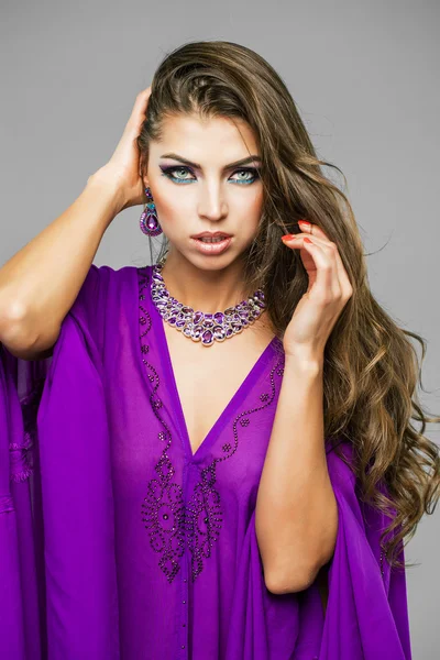 Retrato da jovem mulher sexy em árabe túnica roxo — Fotografia de Stock