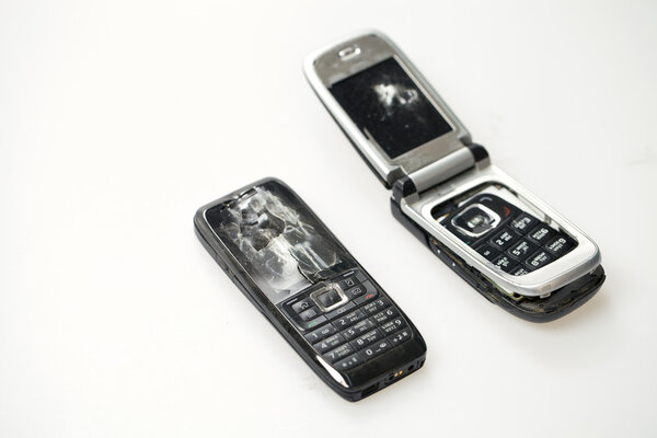 Два сломанных мобильного телефона изолированы на белом
 