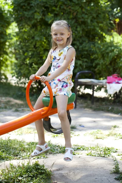 Adorable little girl having fun on a swing outdoor — Stock Photo, Image