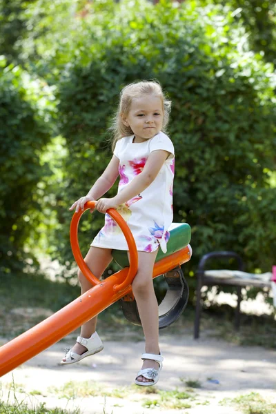 Adorable little girl having fun on a swing outdoor — Stock Photo, Image