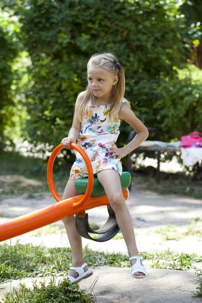 Adorable little girl having fun on a swing outdoor — Stock Photo, Image