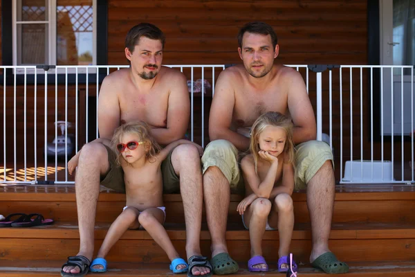 Twee vader zittend op de stappen met hun jonge dochters — Stockfoto