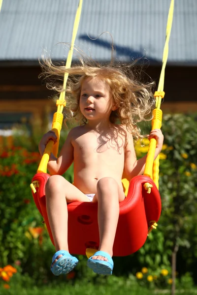 Adorable little girl having fun on a swing outdoor — Stock Photo, Image