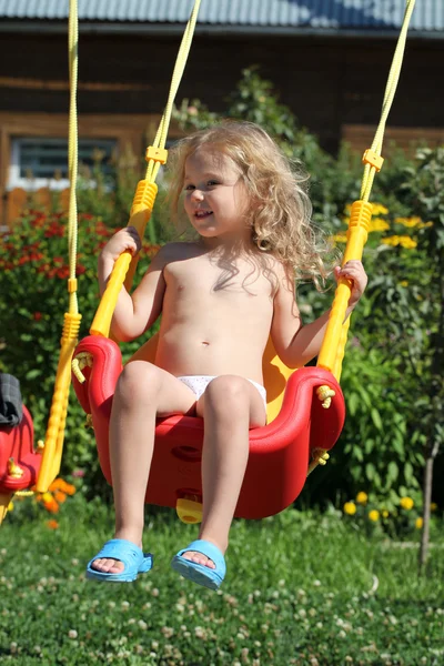 Adorable little girl having fun on a swing outdoor — Stock Photo, Image