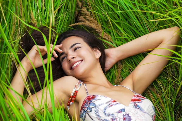 Mujer joven descansando y día acostado sobre hierba verde —  Fotos de Stock