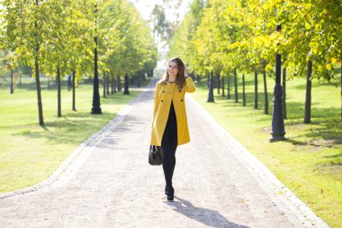 Sonbahar parkta bir bankta oturan güzel kadın