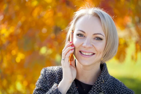 Porträtt av en vacker ung kvinna ringer via telefon — Stockfoto