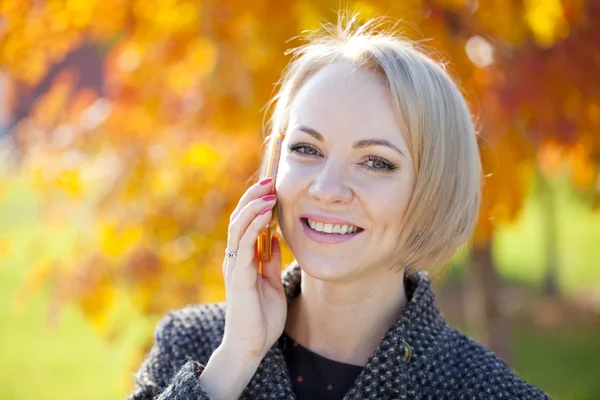 Porträtt av en vacker ung kvinna ringer via telefon — Stockfoto