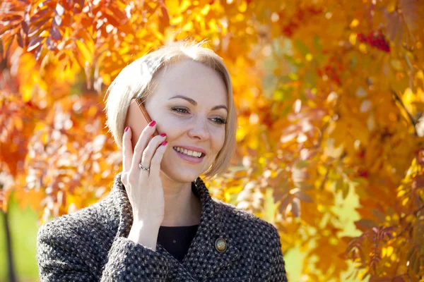 Porträtt av en vacker ung kvinna ringer via telefon — Stockfoto