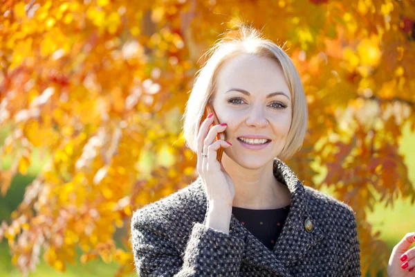 Porträtt av en vacker ung kvinna ringer via telefon — Stockfoto