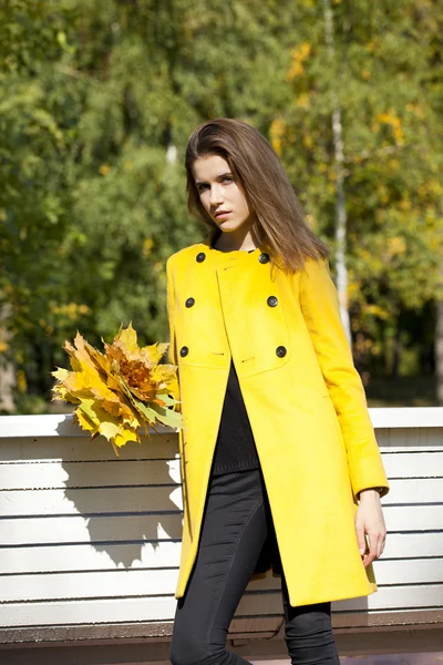 Mujer joven feliz en abrigo amarillo en la calle de otoño —  Fotos de Stock