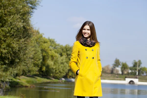Ευτυχισμένη κοπέλα σε κίτρινο παλτό το φθινόπωρο του δρόμου — Φωτογραφία Αρχείου