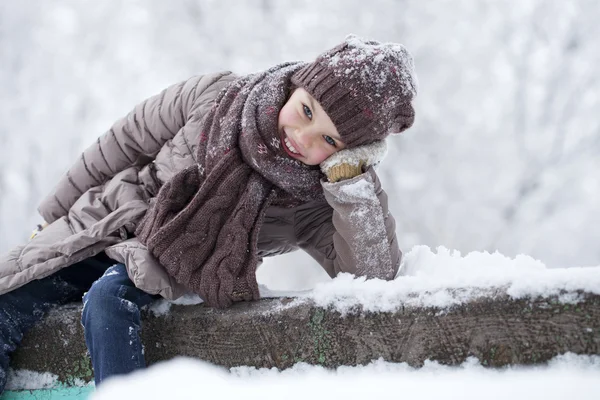 Счастливая маленькая девочка на фоне зимнего парка — стоковое фото