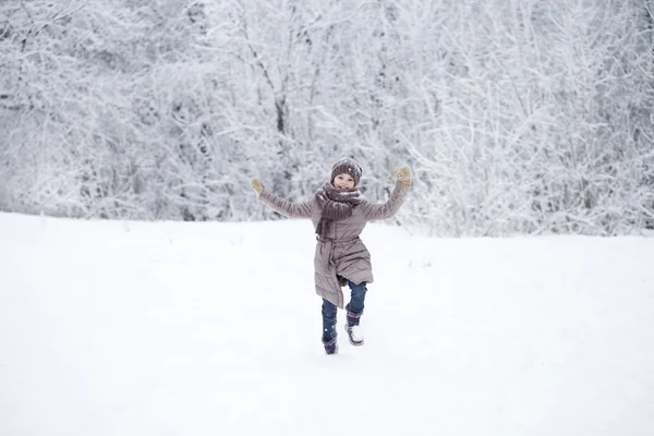 Gelukkig meisje draait op de achtergrond van sneeuw bedekt wint — Stockfoto