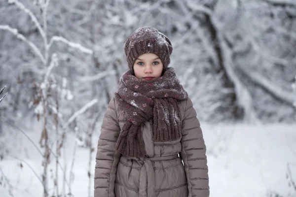 Счастливая маленькая девочка на фоне зимнего парка — стоковое фото