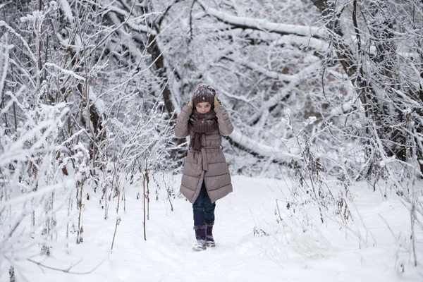 Ευτυχισμένη κοριτσάκι στο φόντο ενός πάρκου χειμώνα — Φωτογραφία Αρχείου