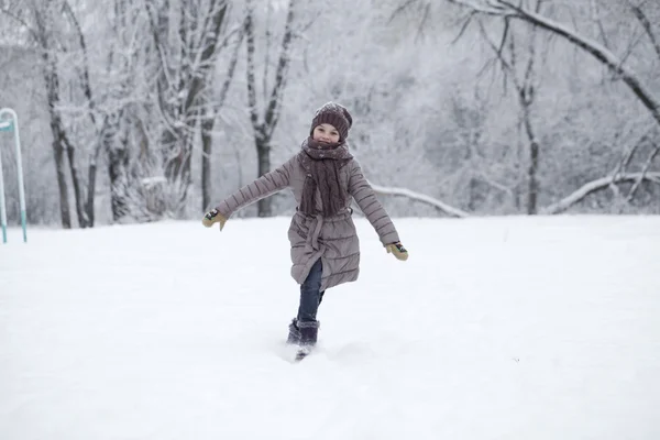 Menina feliz correndo sobre o fundo de neve coberta wint — Fotografia de Stock