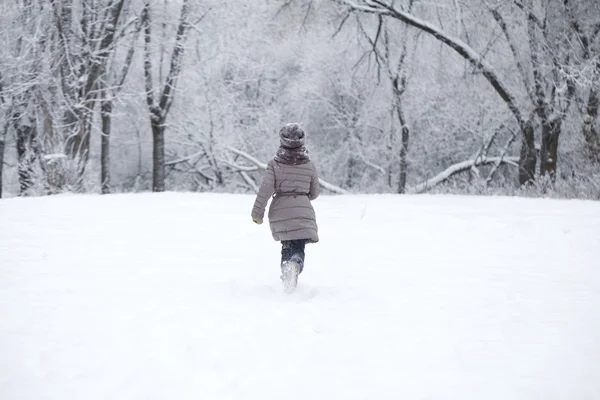 Gelukkig meisje draait op de achtergrond van sneeuw bedekt wint — Stockfoto