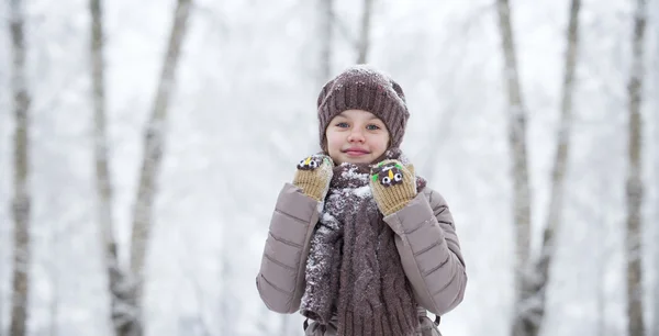 Niña feliz en el fondo de un parque de invierno — Foto de Stock